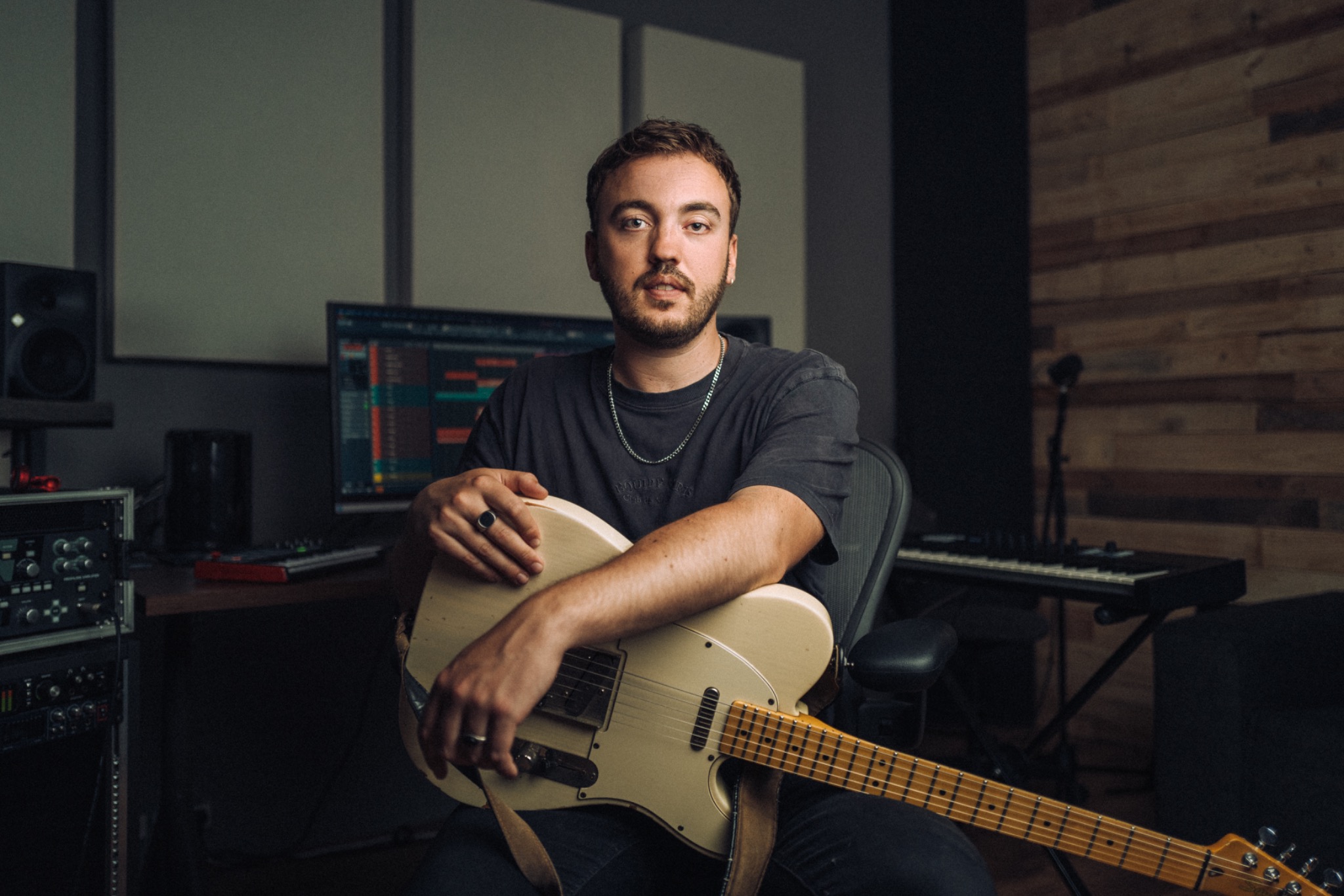 Jerôme Lenders in zijn muziekstudio met een gitaar